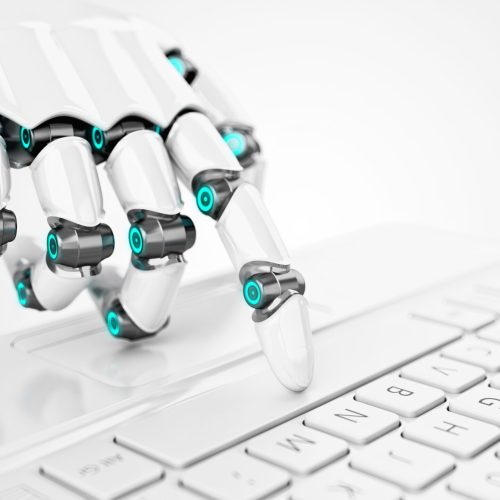 Finger of a white robot touches a laptop keyboard
